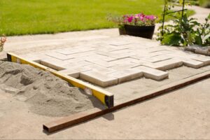 A level is set out to lay paver stones in a garden.