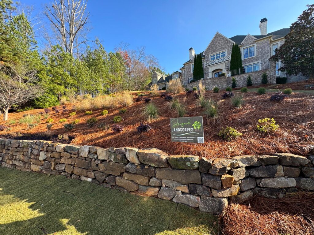 Tucano Stones - Boulder wall with luxury home and landscaping by Designed Landscapes - Johns Creek GA