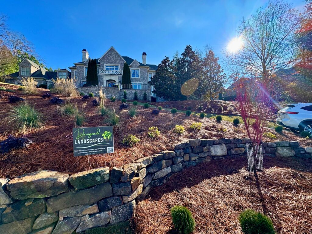 Tucano Stones - Wide view of boulder retaining wall project with sun flare - Johns Creek GA