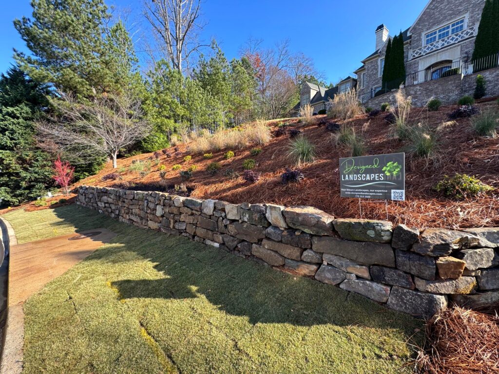 Tucano Stones - Boulder retaining wall with fresh landscaping - Johns Creek GA