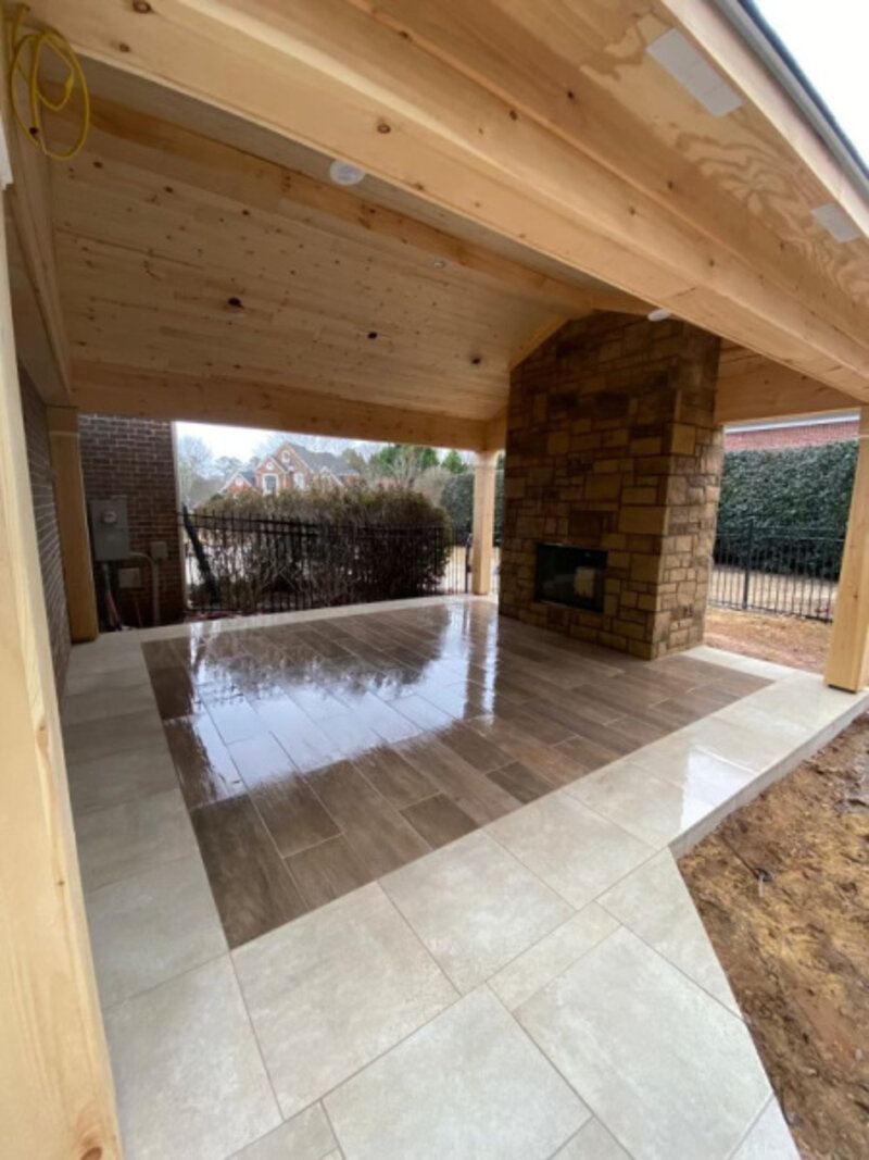 Porcelain paver patio with pergola and stone fireplace in Alpharetta, Georgia