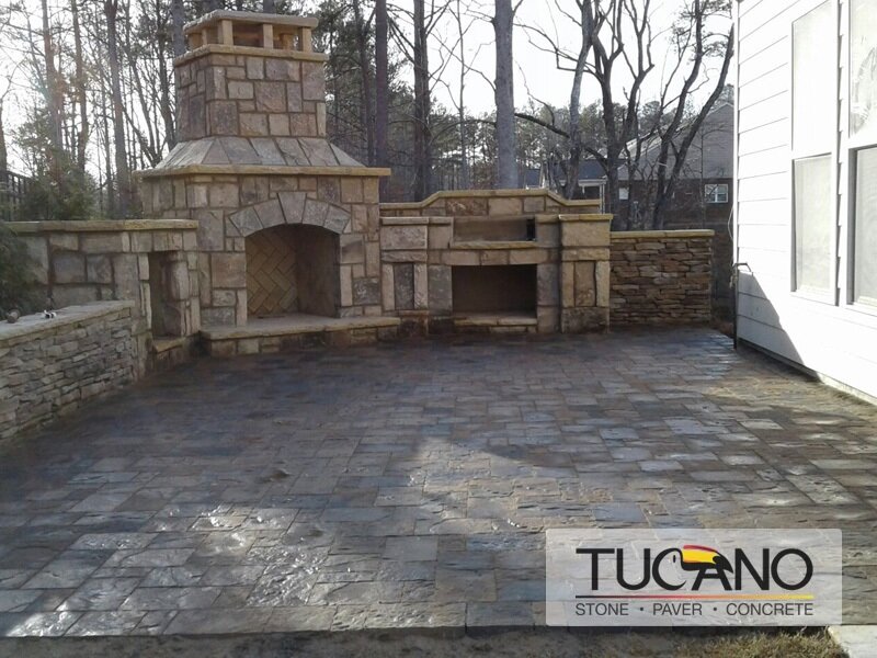 Exterior fireplace with natural stone on Belgard paver patio