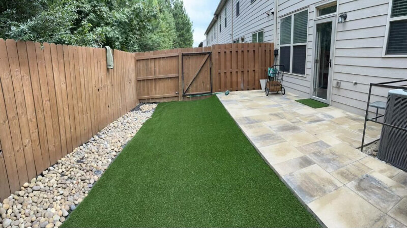 Combination of pavers, artificial turf and river rock bed in Fairburn, GA