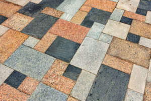Closeup on a section of a driveway with multi-colored pavers.