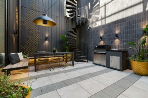 A porcelain paver courtyard with a spiral staircase, grill, table, plants, and seating.